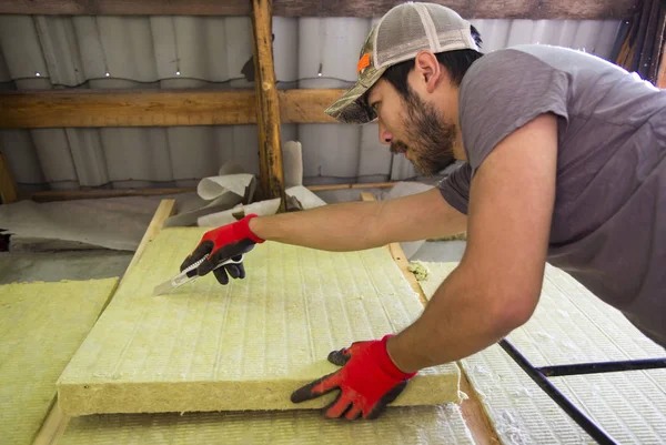 Een Aziatische man opwarming van de aarde zijn huis met behulp van minerale wol — Stockfoto