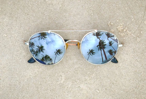 Spiegelende zonnebril close-up op het strand zand met palmbomen reflectie — Stockfoto