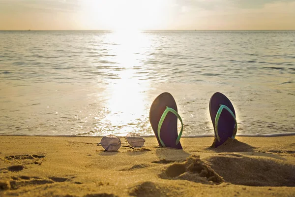 Фліп-флоп і сонцезахисні окуляри на пляжі на заході сонця — стокове фото