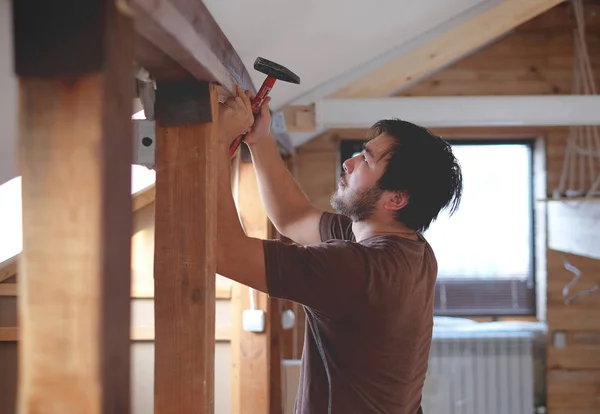 Hombre construyendo una casa y workimg con martillo y madera — Foto de Stock