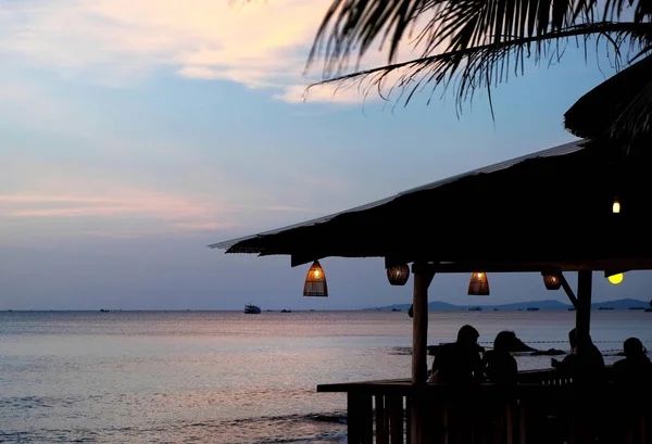 Acogedora cafetería con lámparas de bambú en la playa al atardecer . —  Fotos de Stock