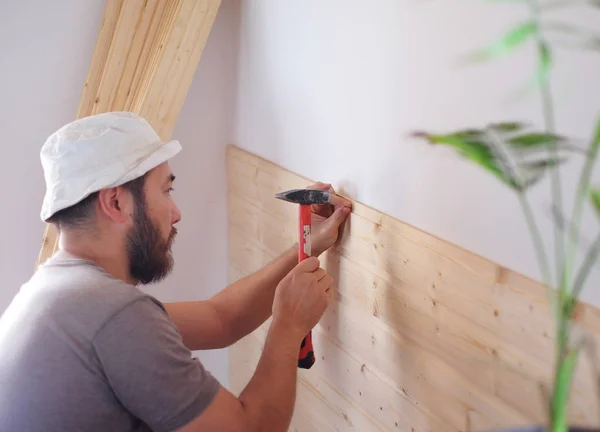 Hombre construyendo una casa y workimg con martillo y madera — Foto de Stock