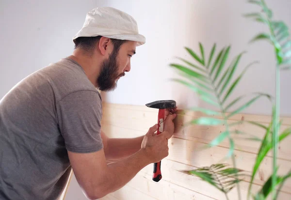 Hombre construyendo una casa y workimg con martillo y madera — Foto de Stock