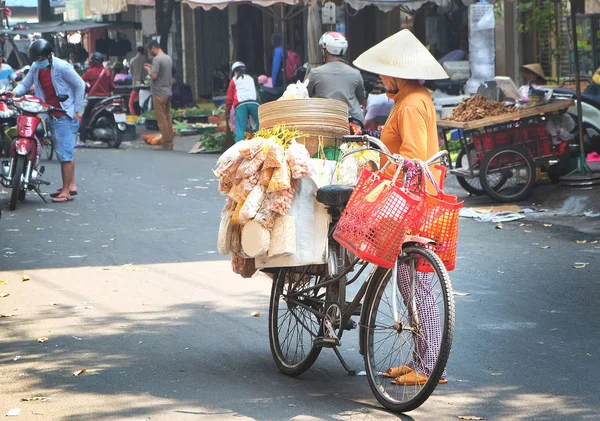 Verkäuferin auf dem Fahrrad auf einem Markt in der Stadt Ho Chi Minh, Vietnam — Stockfoto