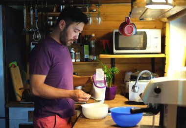 Çekici bir adam rahat ahşap iç mutfak, yemek