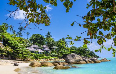 Tayland, Koh Samui adasında büyük taşları ve turkuaz suları olan güzel tropikal sahildeki bungalovlar.