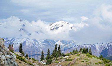 İlkbaharın başlarında Kazakistan 'ın Almaty şehrinin yakınlarında güzel dağlar ve bulutlar.
