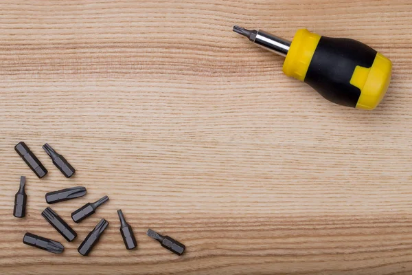 Havadan görünümü tornavida ile parçaları üzerinde ahşap masa ayarla.