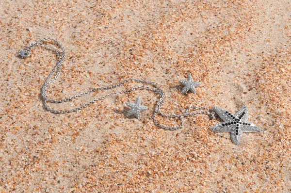 Pendant on sea sand — Stock Photo, Image