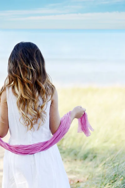 Молода дівчина на пляжі рожевий шарф — стокове фото