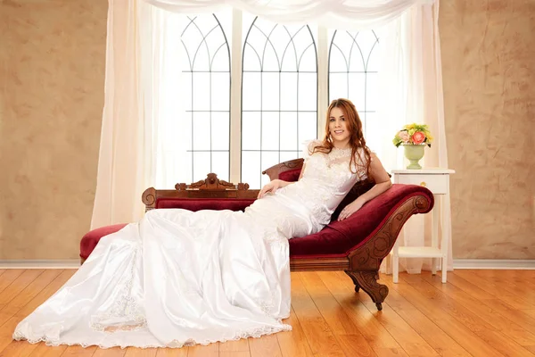 Невеста сидит на обморочном диване у окна — стоковое фото