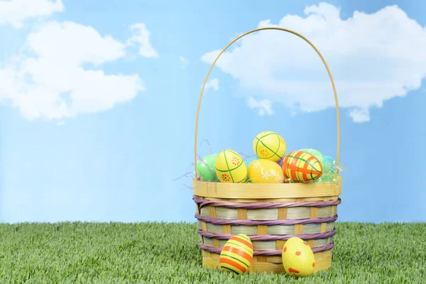 Wicker basket full of colorful easter eggs — Stock Photo, Image