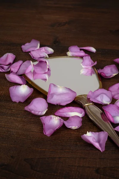 Closeup mirror with rose petals — Stock Photo, Image