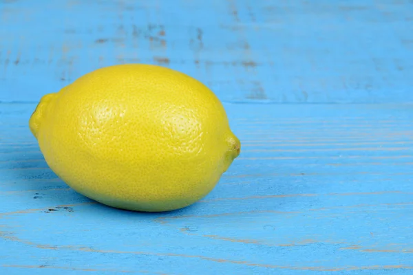 Лимон на голубом деревянном столе — стоковое фото