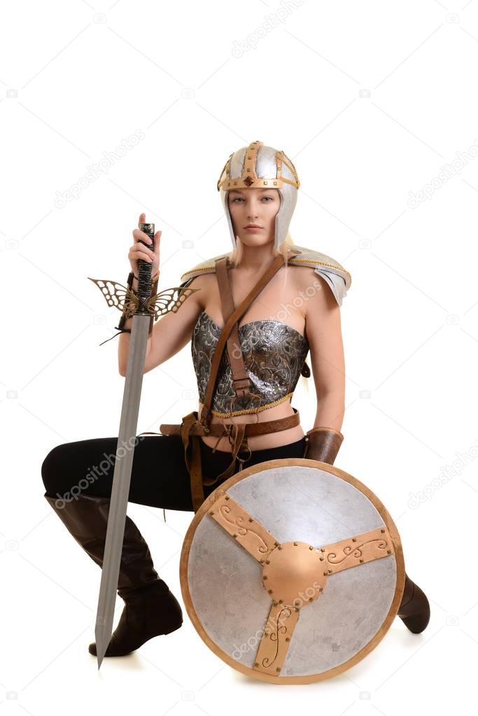 female warrior kneeling with sword and shield