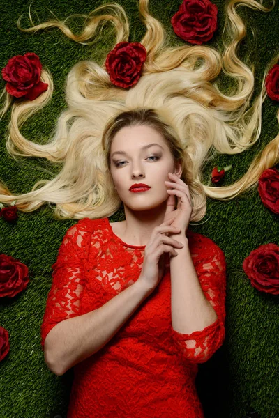 Kobieta, r. w trawie z czerwonych róż — Zdjęcie stockowe