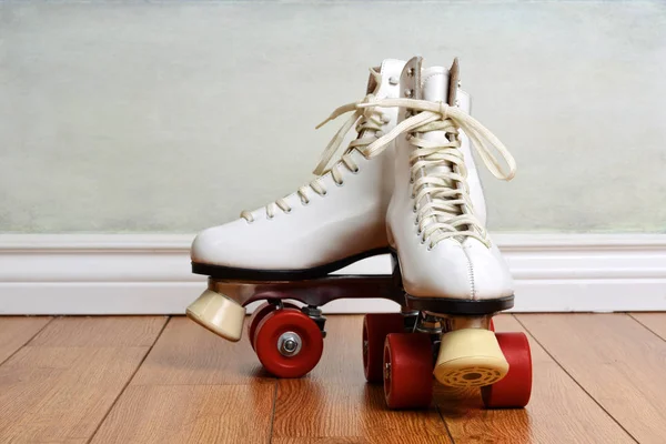 Frauen weiße Quad-Rollschuhe auf Holzboden — Stockfoto