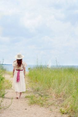 plaj yolu üzerinde yürüyüş şapka giyen kadın