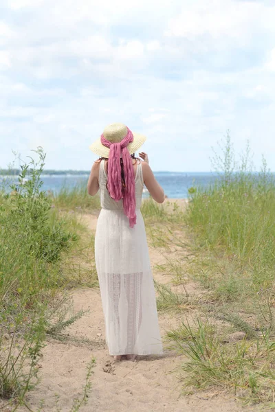 Parte de trás da mulher usando chapéu no caminho da praia — Fotografia de Stock