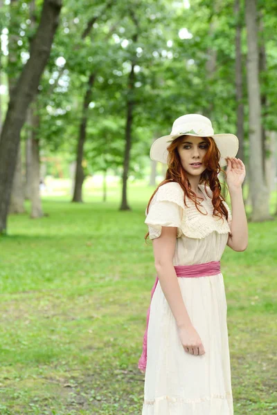 Vintage woman wearing a hat in park setting — Stock Photo, Image