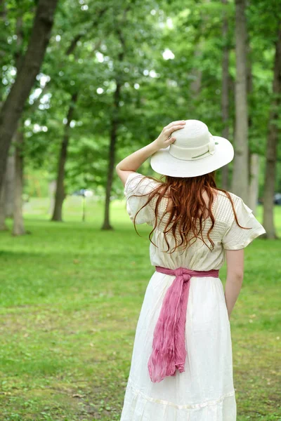 Vintage mulher segurando seu chapéu no parque — Fotografia de Stock