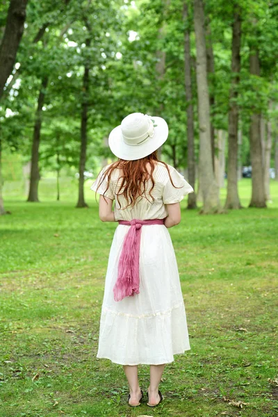 Espalda de mujer pelirroja vintage con sombrero en el parque — Foto de Stock