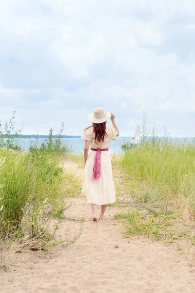 plaj yolunda yürüyen vintage Kızıl saçlı kadın