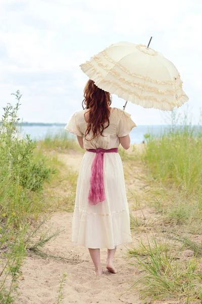 Vintage Frau mit Sonnenschirm am Strand — Stockfoto