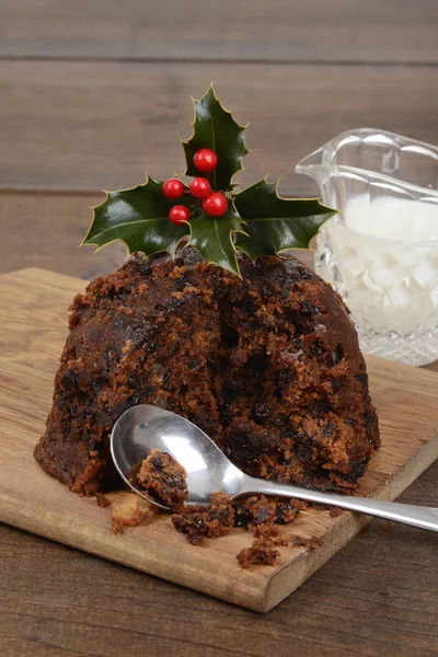 Nahaufnahme geschnitten Weihnachtspudding mit Löffel und Stechpalme — Stockfoto