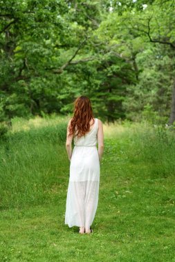 Kızıl saçlı kadın orman izinde