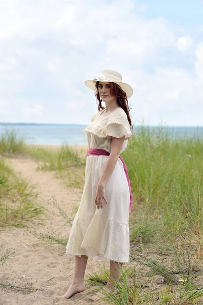 Donna vintage con cappello sul sentiero della spiaggia di sabbia — Foto Stock