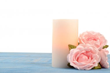 closeup gül ve mavi ahşap üzerine mum