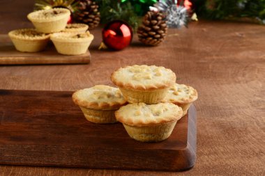 Arka planda meyveli turta ve kıymalı Noel pastaları yığını