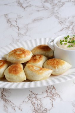 Ekşi kremalı ve taze soğanlı pierojiler.