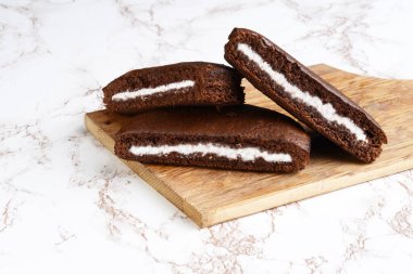 Kesme tahtasında üç dilim çikolatalı pasta.