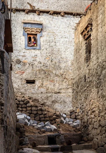 Malý kluk koukal z okna v domě v Léhu — Stock fotografie