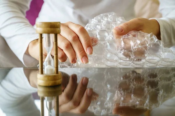 Vrouw handen popping bubble wrap — Stockfoto