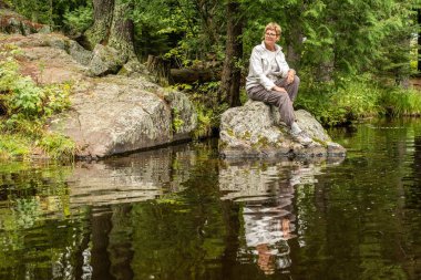 Kadın rock üzerinde oturuyor