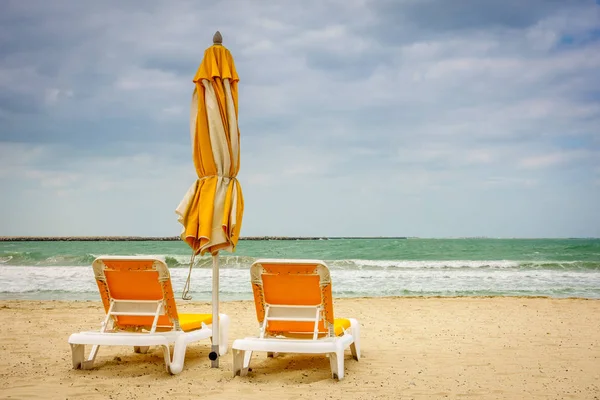 Empty beach with armchairs and umbrella — Stock Photo, Image