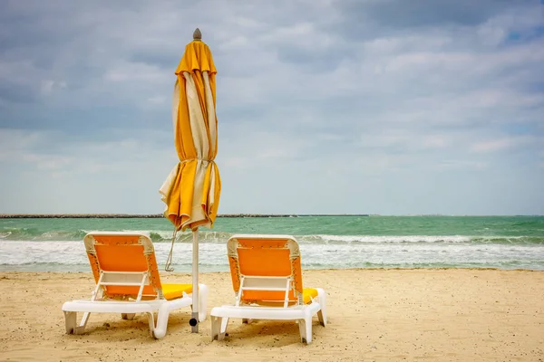 Praia vazia com poltronas e guarda-chuva — Fotografia de Stock