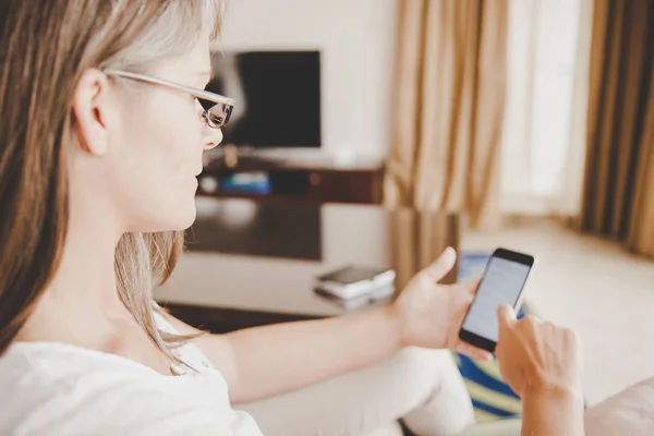 Žena kontrolovat zprávy na svůj mobilní telefon — Stock fotografie