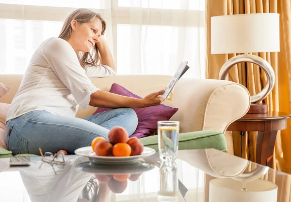 Femme Mûre Détendre Sur Canapé Dans Appartement Avec Magazine — Photo