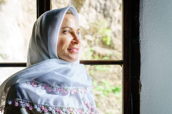 Bosna'da bir derviş manastırda geleneksel başörtüsü giyen bir kadın portresi