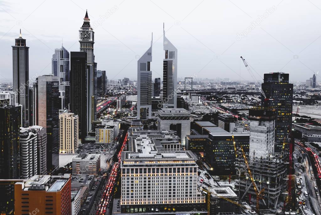 Bird's eye view of Dubai Financial District skyline and rush hour traffic at dusk