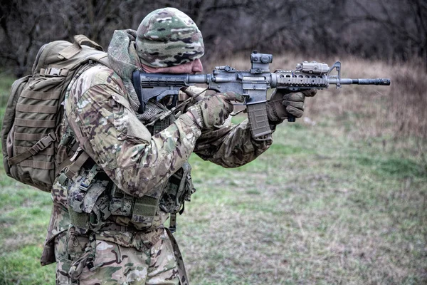 Infantaria apontando rifle durante luta na floresta — Fotografia de Stock