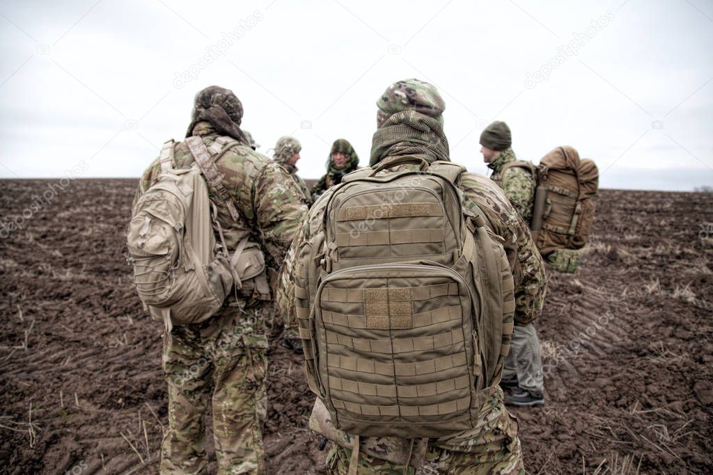 Army soldiers group on march in muddy field