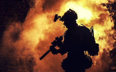 Ateş ve dumanın arka planında asker silueti