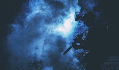 Asker silueti dumanın içinde savaşıyor.