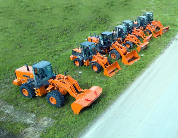 New, shiny and modern orange excavator machines. Royalty Free Stock Images