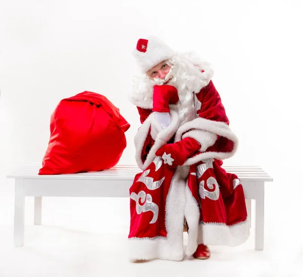 Санта Клаус сидит на скамейке запасных — стоковое фото